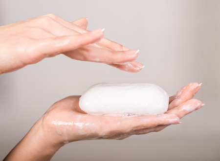 A woman washing her hands with a soap.