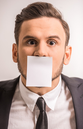 Businessman with a piece of paper stuck on the lips.の写真素材