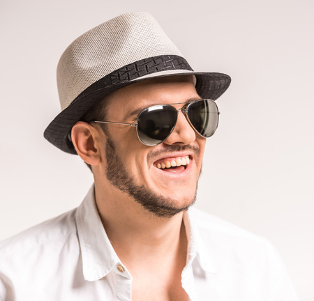 Close-up of young man in glasses and hat is smiling.の写真素材