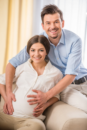 Happy family lifestyle. Portrait of  young couple are expecting a baby.の写真素材