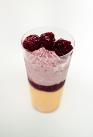 Tasty creamy  layered dessert with berries on white background. Ice-cream with berries in glass.の写真素材