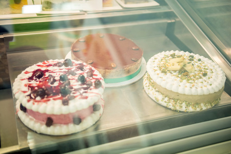 Pastry shop display window with variety of  tasty desserts.の写真素材