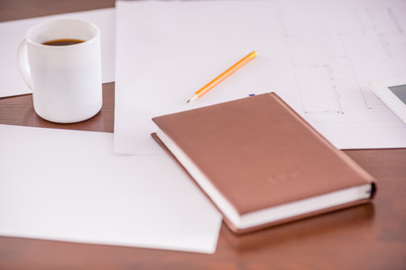 Close-up of table in business office with diary, pencil and cup of tea.の写真素材