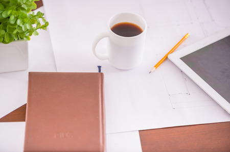 Close-up of table in business office with diary, pencil and cup of coffee.