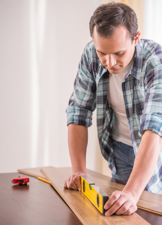 Image of carpenter measuring wooden plank. House renovation service.の写真素材