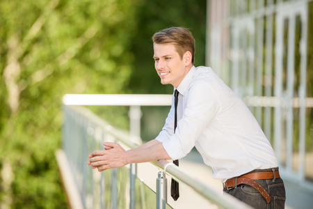 Young man dressed formal resting at office balcony.の写真素材