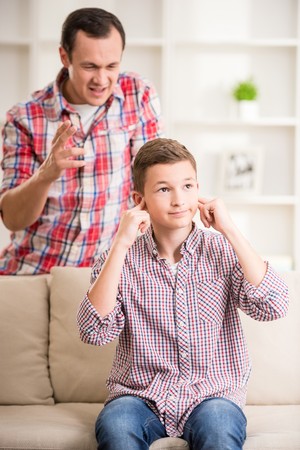 Son closing ears while father scolding  him.の写真素材