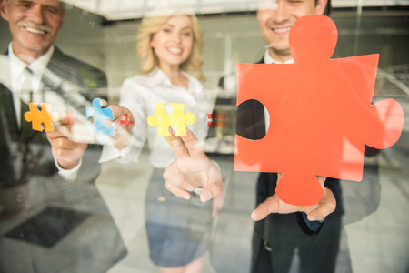 Image of confident business people wanting to put pieces of puzzle together. Team work.の写真素材