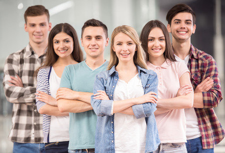 Successful team. Group of cheerful young people standing close to each other and smiling.の写真素材
