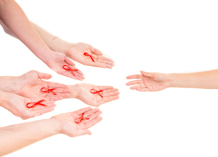 Close-up of hands holding red ribbons to rise AIDS HIV awareness.