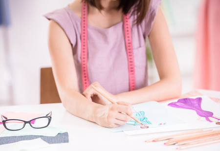 Concentrated female fashion designer working in clothing studio.の写真素材
