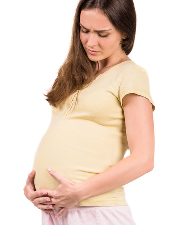 Sad pregnant woman with stomach pain isolated on white background.の写真素材