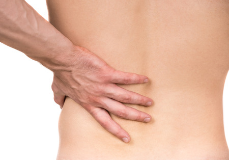 Naked man with lower back pain on white isolated background. Back view. Close-up.