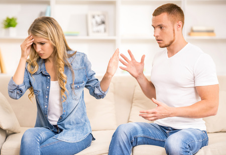 Young angry couple quarreling on a sofa at home.の写真素材