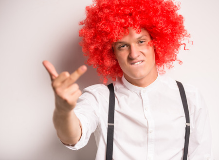 Portrait of a happy young man in a red wigの写真素材