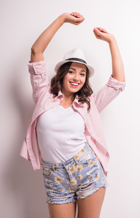 Young beautiful woman in hat is having fun on white background.の写真素材