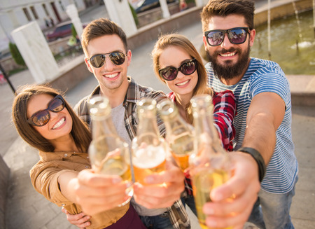 Young happy people walking outdoors. Drinking beveragesの写真素材