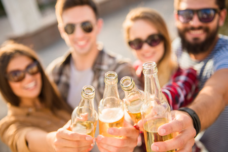 Young happy people walking outdoors. Drinking beveragesの写真素材