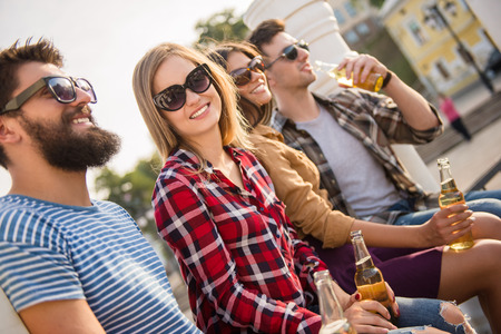 Young happy people walking outdoors. Drinking beveragesの写真素材
