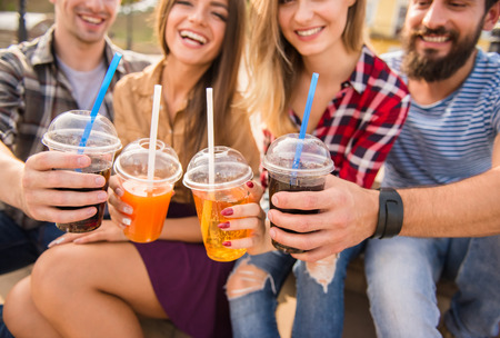 Young people walking outdoors. Sitting in the park and eat fast foodの写真素材