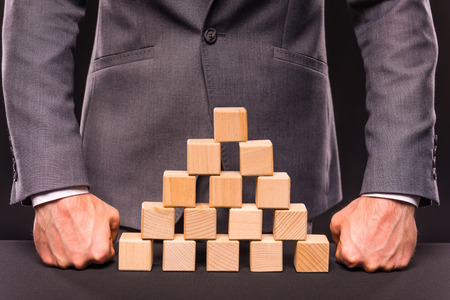 Creative idea. Young businessman presenting creative idea using wood cubes. Studio shooting isolated on Black backgroundの写真素材
