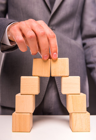 Creative idea. Young businessman presenting creative idea using wood cubes. Studio shooting isolated on Black backgroundの写真素材