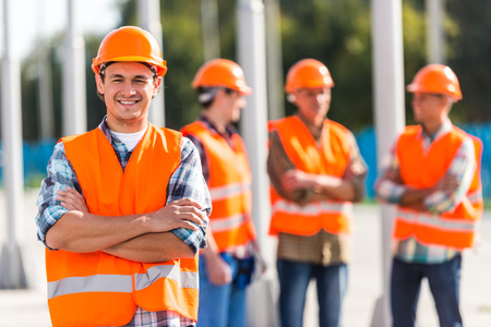 Portrait of male engineers builder in yellow helmet, office center background