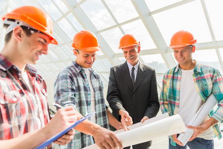 Portrait of male engineers builder in yellow helmet in the office center