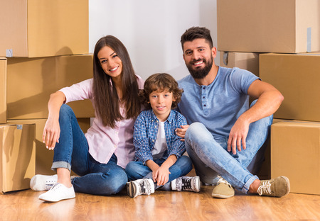 Young happy family moving to a new home with boxesの写真素材