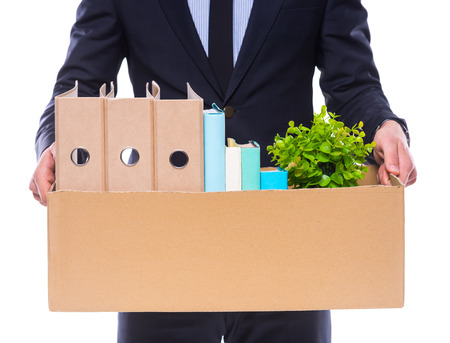 Young happy businessman with box for moving into a new office. Studio shot, isolated on a white backgroundの写真素材
