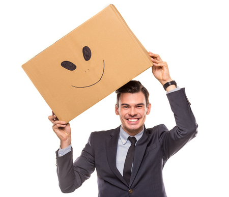 Young happy businessman with box for moving into a new office. Studio shot, isolated on a white backgroundの写真素材