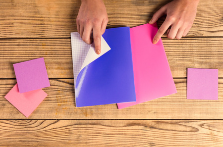 Hands close-up book to use notes on a wooden table