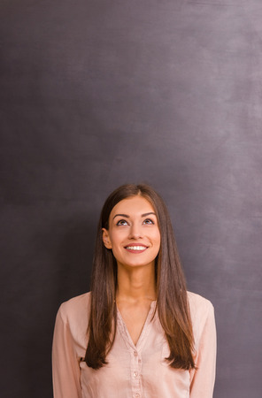 Beautiful young girl expressing their emotions on gray backgroundの写真素材