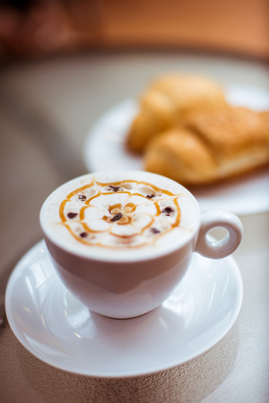 Cup of coffee with croissants on the tableの写真素材