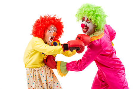 Two funny playful clowns boxing, looking at camera and making funny faces, isolated on a white backgroundの写真素材