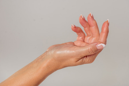 Beautiful hand of middle aged woman, on a gray backgroundの写真素材