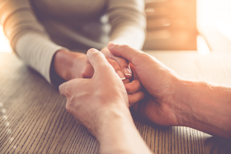 Cropped image of beautiful business lady clasping hands and man calming herの写真素材