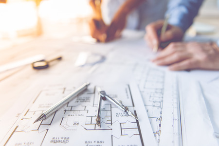 Cropped image of couple of architects working on drafts