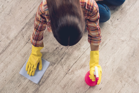 Top view of beautiful young woman in protective gloves cleaning floorの写真素材