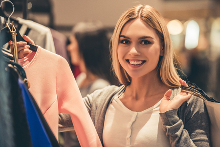 Attractive girl with shopping bag is looking at camera and smiling while doing shopping in the mallの写真素材
