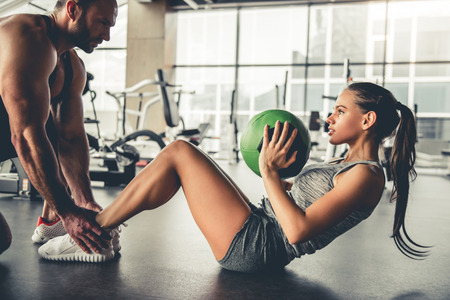 Attractive sports people are working out with fitness balls in gymの写真素材