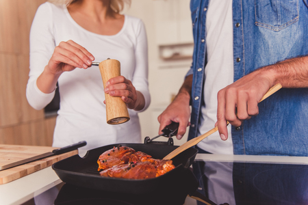 Cropped image of beautiful young couple cooking together in kitchenの写真素材