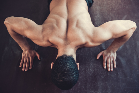 Top view of handsome Afro American boxer with bare torso doing push-ups while warming up at the fight clubの写真素材