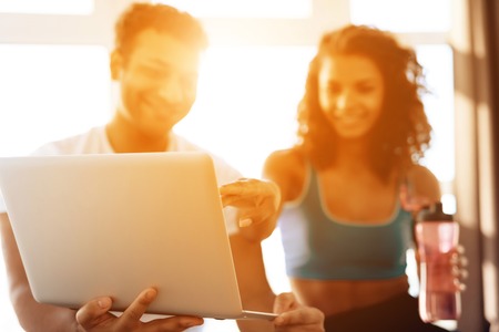 African American couple doing yoga exercises at home. They sit on the floor on yoga mats in a lotus position.の写真素材