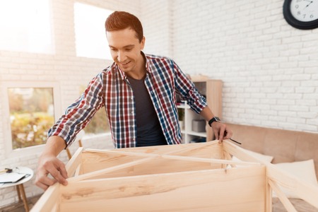 A girl gives a disabled in a wheelchair a cup of tea or coffee in a light modern office.の写真素材