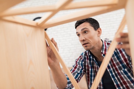 The young man tries himself to fold his bookcase.の写真素材
