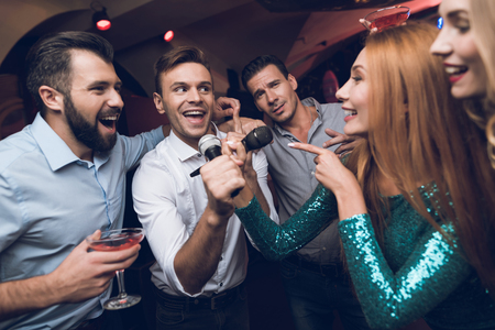 Young people have fun in a nightclub. Three men and three women staged a musical battle.の写真素材