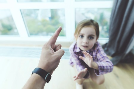 Nurse scolds the girl. The girl is frightened and tries to protect herself from it.の写真素材
