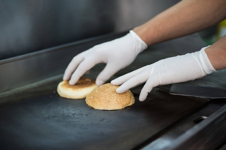 Close up. The process of making a juicy, fragrant burger close-up. All ingredients are toasted on...
