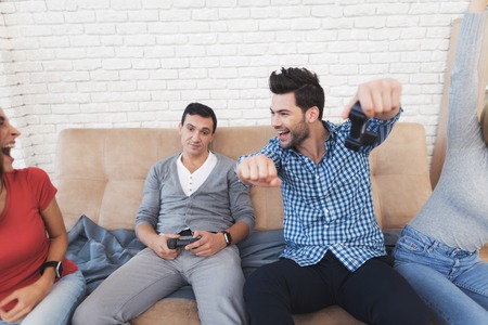 Two guys and two girls play on the game console.の写真素材